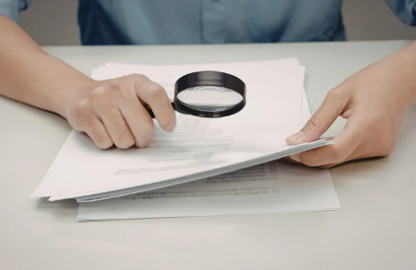 Handen boven document met vergrootglas