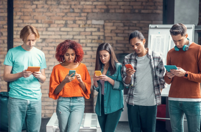 Groep jongvolwassenen kijkend naar smartphones